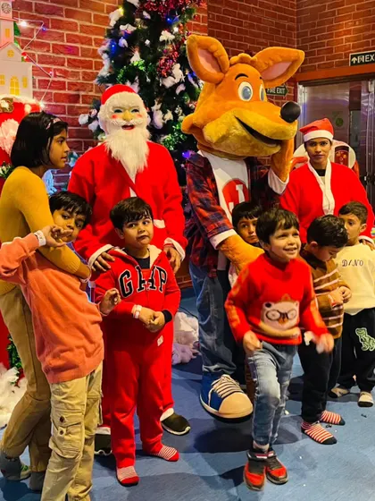 Santa Claus and J the Fox pose with a group of excited children. Our Christmas celebrations are filled with festive cheer, special guest appearances, and holiday-themed activities.