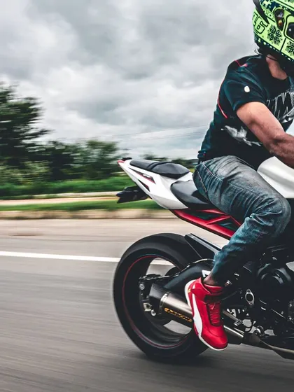 A panning shot from the rear, highlighting the rider's bright red shoes and the motion of the back wheel. This series captures the motorcycle from multiple dynamic angles.