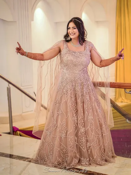 A joyful, candid shot of the bride dancing and smiling on the stairs at her engagement party.