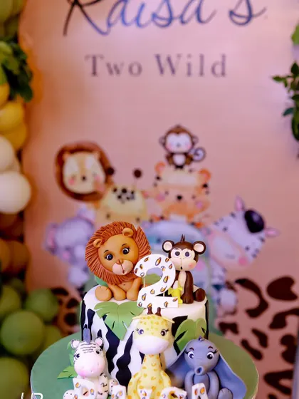 The birthday cake for the "Two Wild" party was a work of art, featuring fondant animals like a lion, monkey, and giraffe, perfectly matching the jungle theme.
