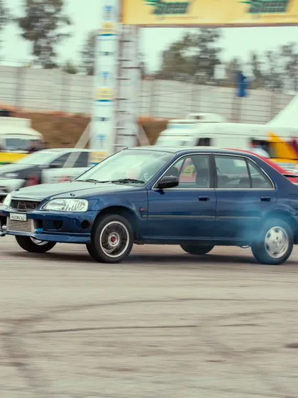 A blue modified Honda City, a classic in the Indian tuning scene, leaving a trail of tire smoke. The nostalgia and passion for these cars run deep in our community.