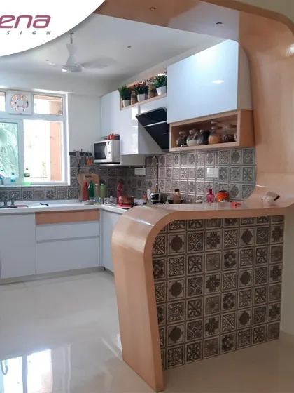 This stylish kitchen features a curved breakfast counter with decorative tiles. We used a mix of open and closed shelving to balance storage and display.