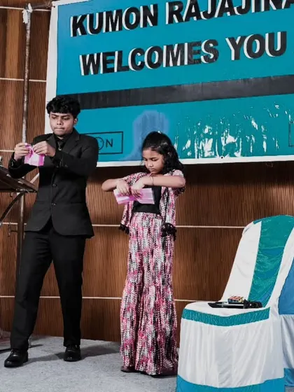 A young girl assists me with a trick on stage at a Kumon event. My interactive performances are great for educational events and workshops, encouraging participation and confidence.