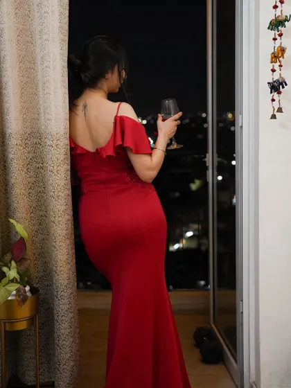 A toast to new beginnings. The red gown and the glass of wine create a classic, celebratory image.