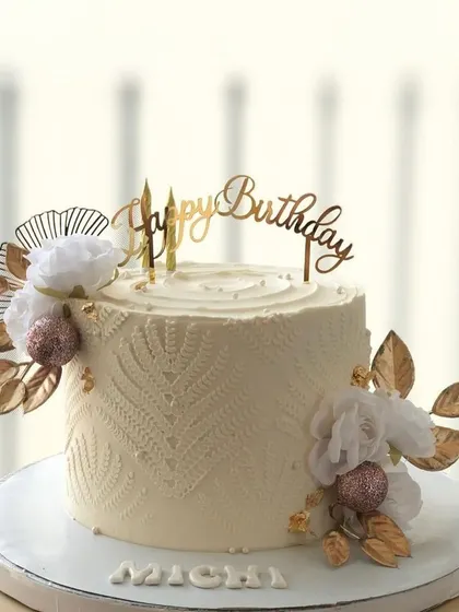 A side view of the elegant white cake with gold and glitter accents.