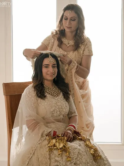 The bride getting ready with her mother, a moment filled with love and tradition, captured in beautiful natural light.