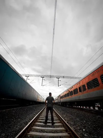A powerful symmetrical shot of me standing on a railway track between two trains. This image symbolizes choices, journeys, and the path of life.