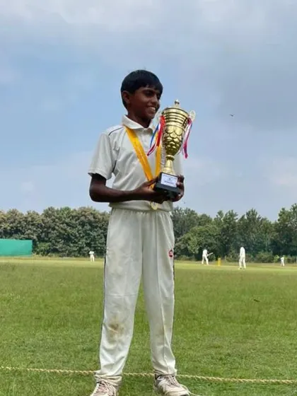 One of our U12 champions, smiling as he holds his trophy after a successful tournament.
