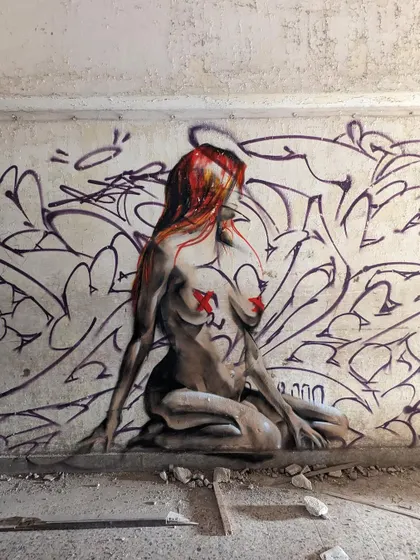 A figurative piece done in a dilapidated building. The crumbling wall and rough textures add to the mood of the artwork.