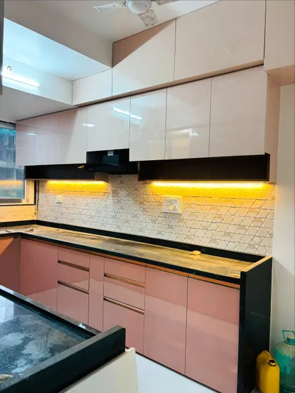 The combination of glossy pink and white cabinets creates a bright and cheerful kitchen environment.
