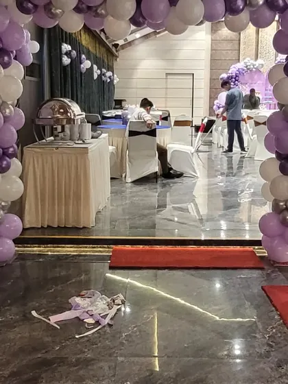 The entrance to the party hall, decorated with a matching purple and silver balloon arch to welcome guests into the celebration.