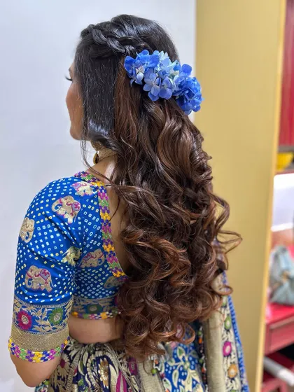 A back view of the half-up style, showing the braid and the placement of the blue hydrangeas.