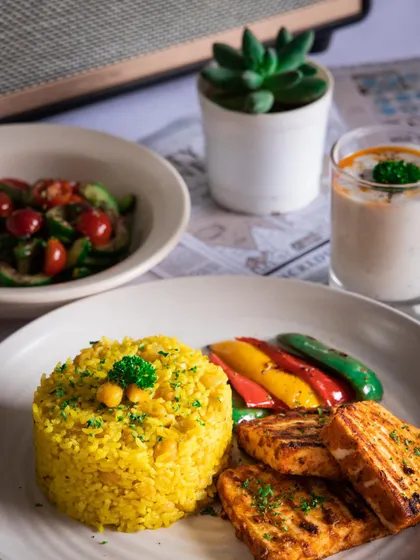 Feeling Shish Tawook for dinner? This plate features paneer with chickpea pilaf, grilled vegetables, and a cool garlic greek yogurt.