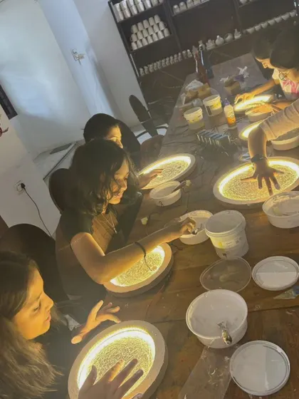 Students deeply engaged in our moon lamp workshop, carefully applying texture paste to create the moon's surface.