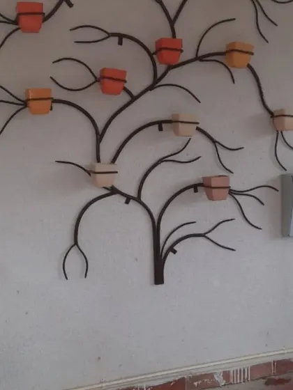 Another version of the tree-shaped wall planter, this time in a dark finish with terracotta-coloured pots. This shows how the same design can be customized to create a different look.