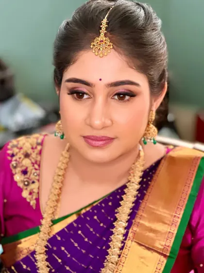A beautiful look for a Varpooja ceremony. The makeup features a pop of pink on the eyes and lips, adding a fresh and modern touch to the traditional event.