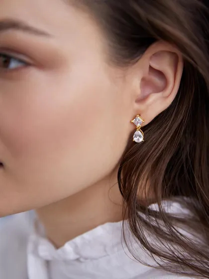A macro-level close-up of a delicate drop earring. This shot is all about the details, capturing the sparkle of the stones and the fine metalwork with perfect clarity. It's ideal for showcasing product craftsmanship.