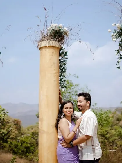A classic pose against grand pillars overlooking a valley. This shot combines architectural elegance with the beauty of the natural landscape for a truly epic feel.