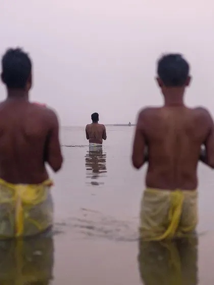 Devotees stand waist-deep in the water, offering prayers to the rising sun during Chhath Mahaparv in Bihar. The composition highlights the communal yet deeply personal nature of the worship.