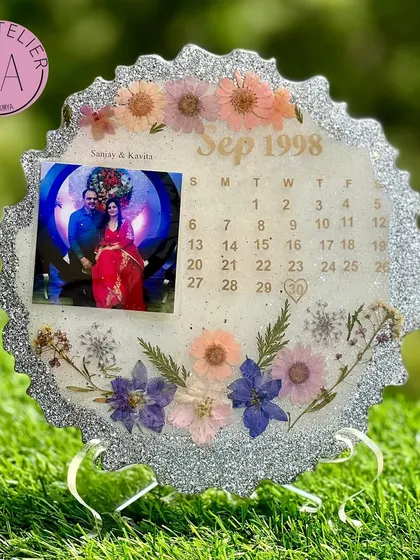A sparkling silver-themed calendar frame celebrating a September 1998 wedding. The glittery border and delicate pastel flowers make this a perfect silver jubilee anniversary gift.