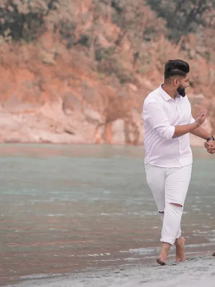 A candid and playful interaction between the couple during their riverside pre-wedding walk.