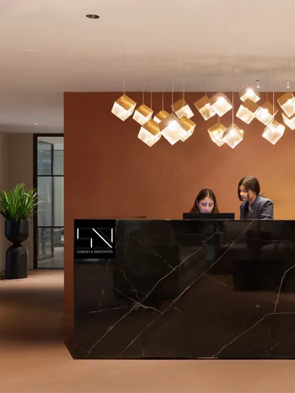 The reception at Jubilee Walk Headquarters, designed to be the first point of contact with the brand's ethos. The solid black marble desk, complemented by a cascade of geometric pendant lights, establishes an immediate sense of modern luxury and professionalism.