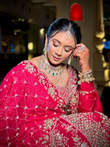 A graceful pose showing the intricate embroidery of the bridal lehenga and the flawless makeup.