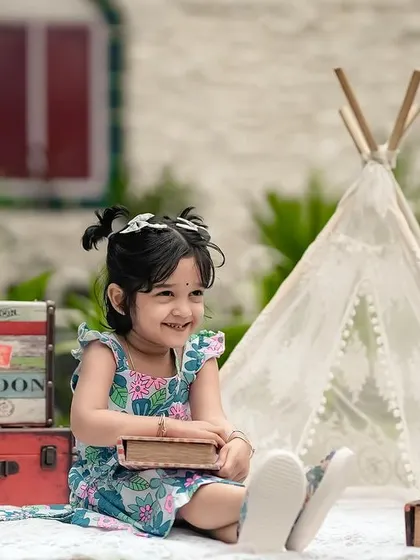 A perfect day for an adventure! This little girl is all smiles during her outdoor shoot, complete with a teepee, globe, and vintage suitcases.