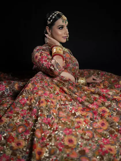 A model with her hair in a sleek ponytail, adorned with a traditional matha patti. This editorial look combines modern and traditional elements for a stunning result.