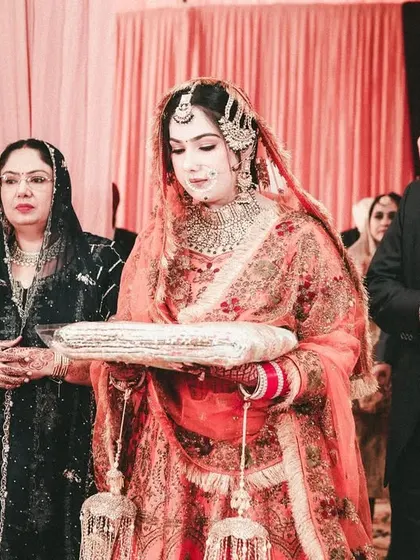 The bride's entry during a Sikh wedding ceremony, accompanied by her parents.
