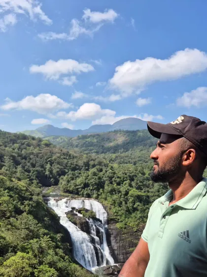 A profile shot with the stunning Mallalli Falls and the surrounding green hills in the background. A perfect picture to capture the memory.