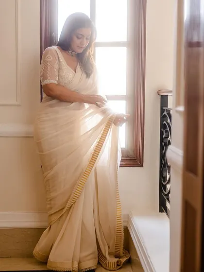 A beautiful, light-filled shot of Kajol. The way the sunlight catches the chiffon fabric shows the saree's delicate texture and elegant drape.