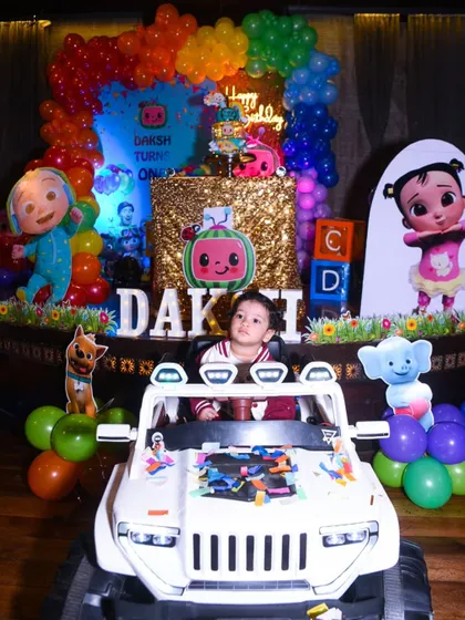 The birthday boy looking cool in his toy car, ready to make a grand entrance at his party.