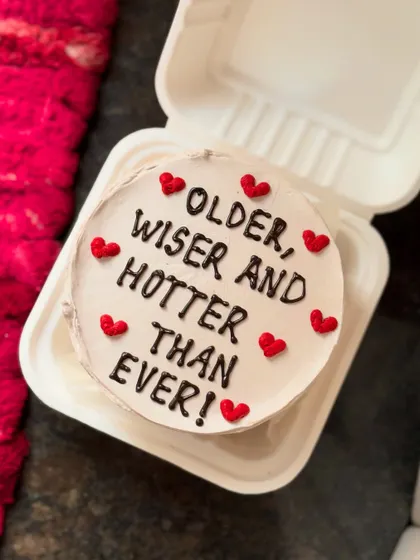 A fun and flirty birthday message: "Older, wiser and hotter than ever!" This cake is decorated with little red hearts, making it a perfect romantic and playful gift.