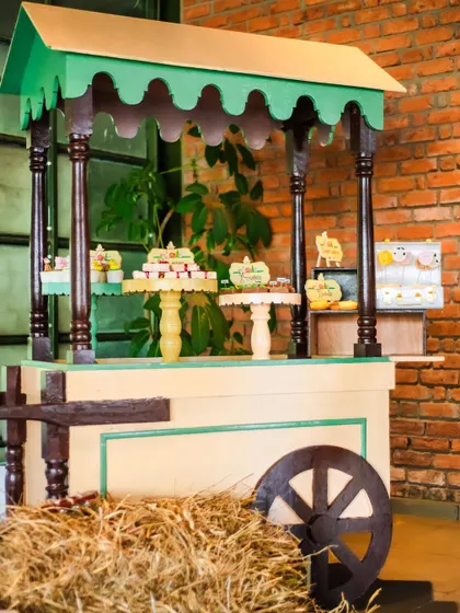 A charming dessert cart made to look like a rustic farm wagon, complete with hay bales. This is a perfect example of how I integrate every element into the party's theme.
