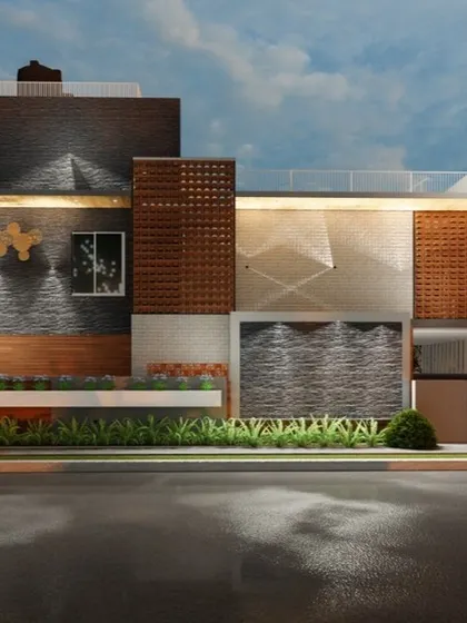 A night-time visualization of another residential building in Siruguppa. The facade lighting is designed to highlight the different textures, including the brickwork, stone cladding, and patterned screens.
