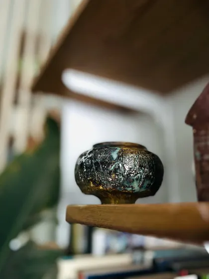This small, intricate piece with a dark, metallic-looking glaze is one of those experiments that keeps us excited. You never know exactly what will come out of the kiln.