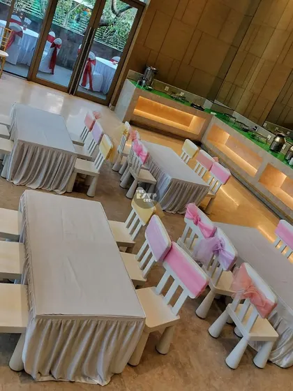 Simple and sweet. These kid-sized tables are covered in white linen, with chairs decorated with pretty pink and yellow sashes.