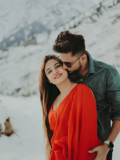 A sweet kiss on the cheek, full of affection and happiness, set against a beautiful snowy background.