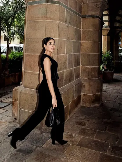 The full view of the black jumpsuit, showing the clean lines and modern silhouette.