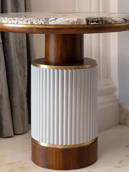 A set of two side tables that serve as both a utility piece and a luxury accessory. The design combines a fluted base with a wooden mid-section and a marble top, all accented with brass.