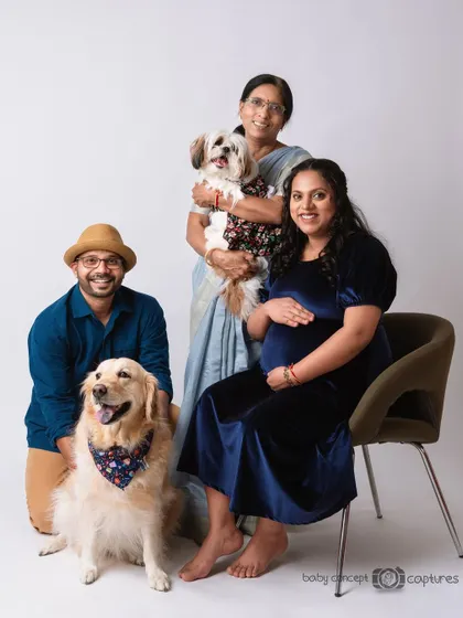A happy, extended family maternity portrait including the grandmother-to-be and two beloved dogs. It’s a joyful celebration of family in all its forms, captured in a relaxed studio setting.