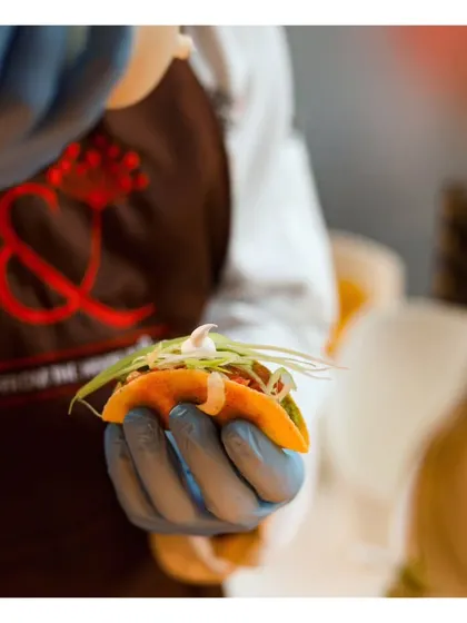 A chef carefully assembles a mini taco, demonstrating the precision and artistry that goes into each of our handcrafted canapés.