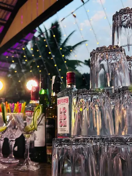 A pyramid of glasses stands ready on the bar, reflecting the ambient light. This artistic arrangement is part of the visual appeal we bring to our mobile bar service.
