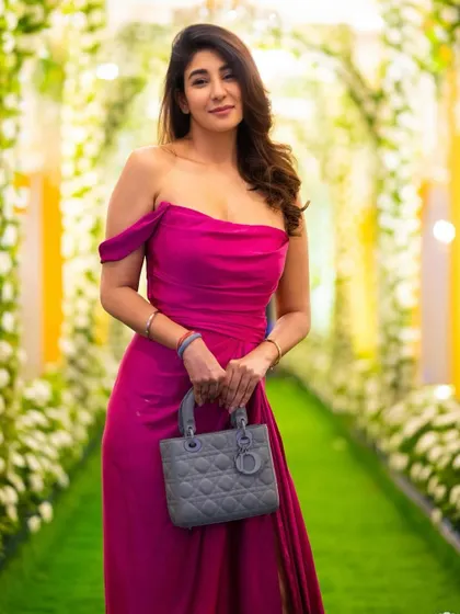 A close-up of this vibrant pink gown. The draped, off-shoulder neckline is elegant and flattering, while the colour makes a bold statement.