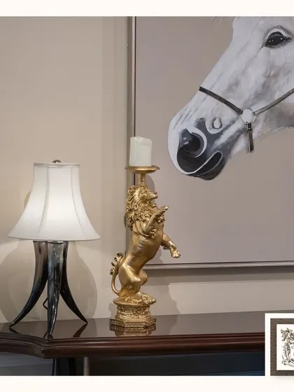 This stunning golden lion candle stand adds a touch of regal sophistication to any room. Here, it is paired with a horn-style lamp and equestrian art to create a powerful and elegant display.