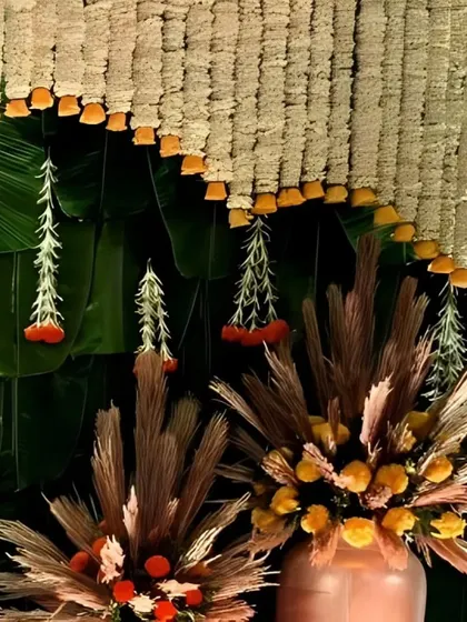 An exquisite fusion of tradition and creativity, this detail shot showcases hanging floral tassels against a backdrop of fresh banana leaves.