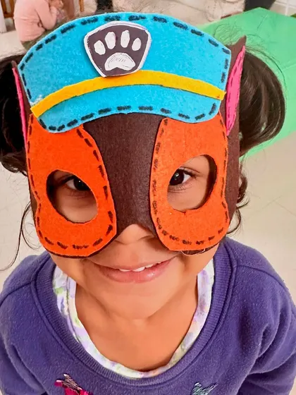 A child proudly wears a handmade Paw Patrol mask. When toys are created by their beloved Playmakers, they hold a special meaning and inspire hours of imaginative play.