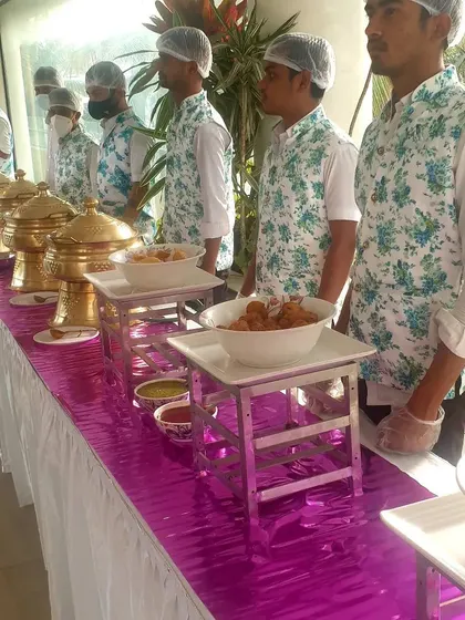 A full view of the buffet line with my staff ready to serve. We use hairnets and gloves to ensure the highest standards of food safety.