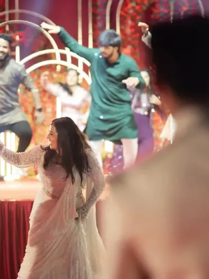 A view from behind the groom as he watches his bride and her friends perform a surprise dance.
